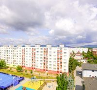 View from Pod Hájom Street in Dubnica nad Váhom towards apartment buildings and a sports facility.