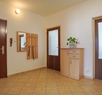 A hallway with tiles, wooden doors, a mirror, and a dresser in a 3-room apartment.