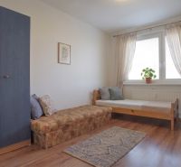 A room in a 3-room apartment with a bed, a wardrobe, and a floor with a wooden decor.