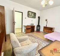 Living room in a family house with tiled stove, furniture, and wooden decor flooring.