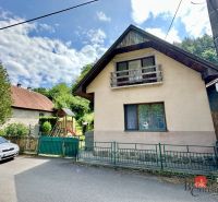 A family house in Žiar nad Hronom with a wooden balcony and a garden with climbing frames.