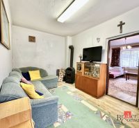 Living room in a family house with a comfortable sofa, television, and stove.