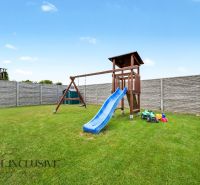 A children's playground with a swing and a slide in a family house in Vozokany.