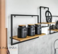 Black canisters for coffee, tea, sugar on a shelf in a family house.
