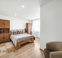 A bedroom in a family house with wooden furniture and a wood-patterned floor.