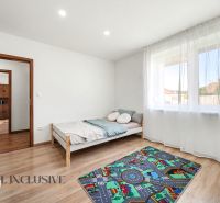 A bright room in a family house with a wooden decor floor and a children's carpet.