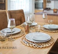 Dining table with plates, glasses, cutlery in a family house.