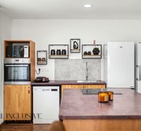 A stylish kitchen with white appliances, cooking, and shelves in a family house.