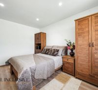 A bedroom in a family house with a wooden decor floor and wooden furniture.