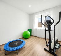 Family house with an exercise room, cardio trainer, and flooring with a wooden design.