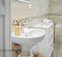 Bathroom in a family house with a sink and decorative tiles.