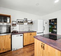 A kitchen in a family house with white appliances, wooden decor, and modern equipment.