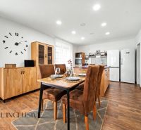 Dining room in a family house with a table, chairs, and a floor with a wooden decor.