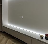 A wall with lighting and a floor with wooden decor in a 2-room apartment.