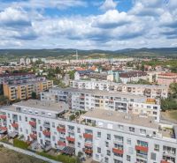 Pezinok, Silvánová: View of multi-storey buildings with hills in the background.