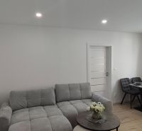 A bright living room in a 3-room apartment with a sofa and a dining table.