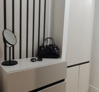 In the 3-room apartment, there is an entrance hall with coat hooks, a wardrobe, and a floor with a wooden decor.