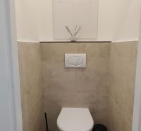 A toilet with tiling and decoration in a 3-room apartment.