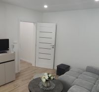 Living room with a comfortable sofa and wooden decor flooring in a 3-room apartment.