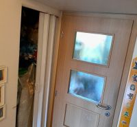 Interior of a 2-room apartment with wooden entrance doors and a built-in wardrobe.
