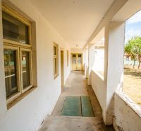 The exterior of a family house in Kapince with older windows and a veranda.