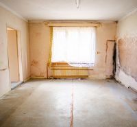 The interior of a family house with peeling wallpaper, neglected walls, and old tiles.