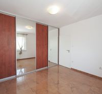 A wardrobe with mirrors in a 3-room apartment, a floor with a wooden decor.