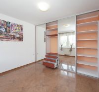 A bright room with a large built-in wardrobe and decorative flooring in a 3-room apartment.