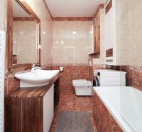 A bathroom in a 3-room apartment with a built-in bathtub, sink, and washing machine.