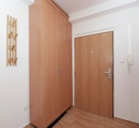 Entrance hall in a 3-room apartment with storage space and coat hooks, floor with wooden decor.