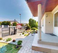 Entrance to a family house in Senec with an ornamental garden and a paved walkway.