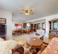 Living room in a family house with a television, wooden furniture, and a floor with a wooden decor.
