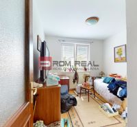 A room in a family house with a bed, a wardrobe, and a window with daylight.