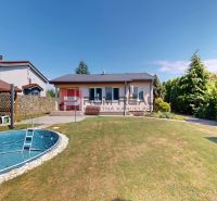A family house in Turany with a swimming pool, landscaped garden, and trees on the property.