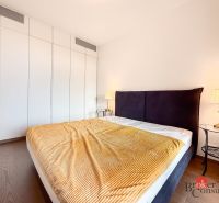 Bedroom in a 2-room apartment with a bed, nightstands, and a floor with a wood decor.