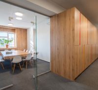 Offices with wood-patterned flooring and glass doors, furnished with chairs and a table.