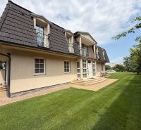 A family house in Senec with a sloped roof, balconies, and a well-maintained garden.