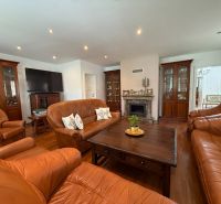 Living room in a family house with leather sofas and a floor with a wooden decor.