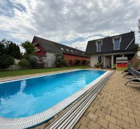 A family house in Senec with a swimming pool in the garden and a terrace with garden furniture.