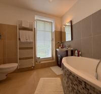 Bathroom with a bathtub, sink, and toilet in a family house.