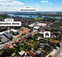 Aerial view of family houses in Senec with a nearby elementary school and lakes.