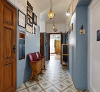 A hallway in a 2-room apartment with patterned tiles and decorations on the walls.
