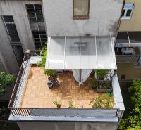 A spacious terrace with wooden decor and garden furniture in a 2-room apartment.