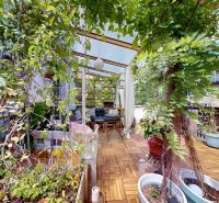 Furnished terrace with plants and seating, 2-room apartment with wood-patterned flooring.