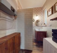 Bathroom in a 2-room apartment with a sink, mirror, and floor with wooden decor.