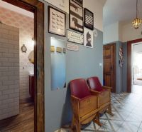 Interior of a 2-room apartment with colorful tiles, wooden decor, and retro chairs.
