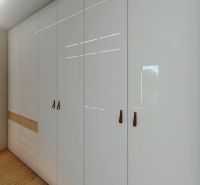 Built-in wardrobe with smooth white doors and brown handles in a 3-room apartment.