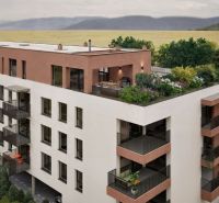 A new building on Brigádnická Street in Piešťany with a terrace and greenery, suitable for residential living.