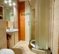 Bathroom in a holiday apartment with ceramic tiles and a shower enclosure.