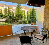 Balcony of a holiday apartment with a view of greenery and garden furniture in Podhájska.